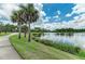 Scenic walking path alongside a tranquil lake with lush landscaping at 11409 Okaloosa Dr, Venice, FL 34293