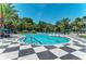 Community pool with checkered tile deck and surrounding landscaping at 11409 Okaloosa Dr, Venice, FL 34293