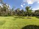 Spacious backyard with lush green grass and mature trees at 11945 Lovegrass St, Venice, FL 34293