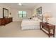 Spacious bedroom with a king-size bed, dresser, and nightstand at 11945 Lovegrass St, Venice, FL 34293