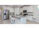 Modern kitchen with white cabinets, granite countertops, and stainless steel appliances at 11945 Lovegrass St, Venice, FL 34293