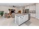 Open concept kitchen with island, granite countertops, and adjacent living area at 11945 Lovegrass St, Venice, FL 34293
