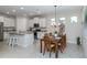 Open kitchen and dining area with granite counters, stainless steel appliances, and wood dining table at 11945 Lovegrass St, Venice, FL 34293