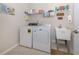 Bright laundry room, washer, dryer and utility sink at 11945 Lovegrass St, Venice, FL 34293