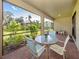 Relaxing screened patio with seating area, overlooking a lush green backyard at 11945 Lovegrass St, Venice, FL 34293