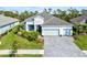 Two-story house with a large driveway, landscaping, and a neighborhood view at 12460 Davie Ct, Venice, FL 34293