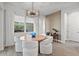 Modern dining room with a round table and white chairs at 12460 Davie Ct, Venice, FL 34293