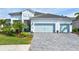 White house with light blue garage doors and a paver driveway at 12460 Davie Ct, Venice, FL 34293