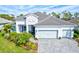 Two-story house with light gray roof, white walls, and light blue garage doors at 12460 Davie Ct, Venice, FL 34293