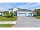 Beautiful two-story home with light-colored siding, three-car garage, and lush landscaping at 12460 Davie Ct, Venice, FL 34293