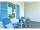 Relaxing front porch with blue adirondack chairs and blooming geraniums at 12460 Davie Ct, Venice, FL 34293