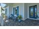Front porch with blue chairs, a table, and potted plants at 12460 Davie Ct, Venice, FL 34293