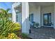 Inviting front porch with blue chairs, potted plants, and a spacious layout at 12460 Davie Ct, Venice, FL 34293