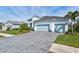 Two-story home with light-colored siding, light blue garage doors, and a paver driveway at 12460 Davie Ct, Venice, FL 34293