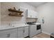 Bright laundry room with white cabinets, washer, dryer, and a built-in sink at 12460 Davie Ct, Venice, FL 34293