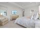 Main bedroom with a king-size bed, dresser, and a comfortable armchair at 12460 Davie Ct, Venice, FL 34293