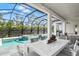 Covered patio with pool, spa, and outdoor dining area at 12460 Davie Ct, Venice, FL 34293