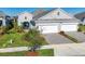 Two-car garage, gray exterior, landscaping, and a paved driveway at 12488 Palatka Dr, Venice, FL 34293