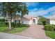Tan two-story house with tile roof, white garage door, and landscaped yard at 13240 Guyana St, Venice, FL 34293