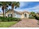 Tan two-story house with tile roof, white garage door, and landscaped yard at 13240 Guyana St, Venice, FL 34293