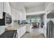 Spacious kitchen with white cabinets, stainless steel appliances, and views to dining area at 13240 Guyana St, Venice, FL 34293