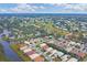 Aerial view of community with golf course, lake, and numerous houses at 135 Braemar Ave, Venice, FL 34293