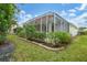 Backyard view of screened patio and landscaping at 135 Braemar Ave, Venice, FL 34293