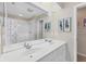 Bathroom with double vanity, shower, and large mirror at 135 Braemar Ave, Venice, FL 34293
