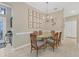 Bright dining area with glass table and six chairs, adjacent to entryway at 135 Braemar Ave, Venice, FL 34293