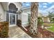 Front entry with decorative screen door and mature palm tree at 135 Braemar Ave, Venice, FL 34293
