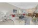 L-shaped sectional sofa and large TV in an open-concept living space at 135 Braemar Ave, Venice, FL 34293