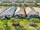 Aerial view of three houses with lanais and tropical landscaping at 13864 Posada St, Venice, FL 34293