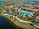 Aerial view of a luxury community with pool, clubhouse, and lush landscaping at 13864 Posada St, Venice, FL 34293