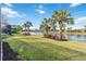 Lakefront backyard with lush landscaping and a screened porch at 13864 Posada St, Venice, FL 34293