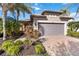 Single-story home with gray garage door and landscaped yard at 13864 Posada St, Venice, FL 34293