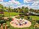 Circular fire pit surrounded by white Adirondack chairs in a brick patio at 13864 Posada St, Venice, FL 34293