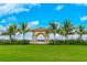 White gazebo with arched entryway, surrounded by palm trees and lush landscaping at 13864 Posada St, Venice, FL 34293