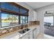 Kitchen with a view, featuring a double sink and modern cabinets at 13864 Posada St, Venice, FL 34293