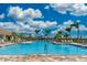 Community pool with plenty of lounge chairs and palm trees at 13864 Posada St, Venice, FL 34293