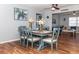 Dining area with a farmhouse table and blue chairs, hardwood floors and ceiling fan at 140 Columbia Rd, Venice, FL 34293