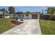Front yard with landscaping and a paved driveway leading to the garage at 140 Columbia Rd, Venice, FL 34293