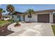 House exterior featuring a landscaped yard, driveway, and attached garage at 140 Columbia Rd, Venice, FL 34293