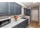 Renovated kitchen with dark cabinets, marble countertops, and stainless steel appliances at 140 Columbia Rd, Venice, FL 34293