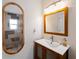 Bright bathroom with a wooden vanity and an oval mirror at 1423 Avenida Del Circo # 1C, Venice, FL 34285
