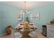 Charming dining area with glass-top table and modern light fixture at 1423 Avenida Del Circo # 1C, Venice, FL 34285