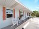 Charming beach cottage with a covered porch and white chairs at 1423 Avenida Del Circo # 1C, Venice, FL 34285