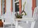Inviting front porch with white chairs and potted plants at 1423 Avenida Del Circo # 1C, Venice, FL 34285