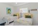 Bedroom with twin beds, yellow accents, and coastal art at 1531 Placida Rd # 1-103, Englewood, FL 34223