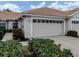 Exterior of a beige villa with a two-car garage and well-manicured landscaping at 1931 San Silvestro Dr, Venice, FL 34285