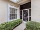 Front entry with a decorative screen door and lush green bushes at 1931 San Silvestro Dr, Venice, FL 34285